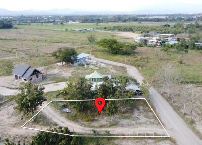 Aerial view of a marked land plot in a rural area with surrounding greenery