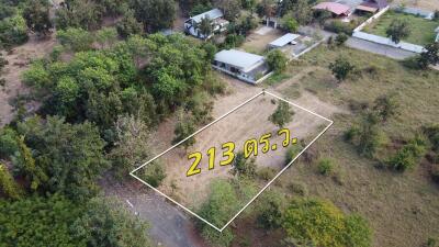 Aerial view of a land plot with surrounding greenery and buildings