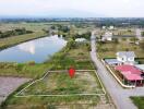 Vacant plot of land next to houses and a body of water