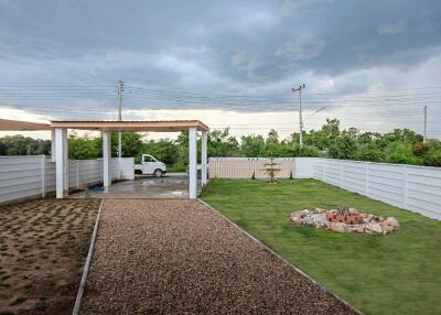 Spacious backyard area with a carport and landscaped garden