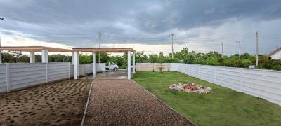 Spacious backyard area with a carport and landscaped garden