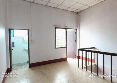 A modest bedroom with tiled flooring and good lighting