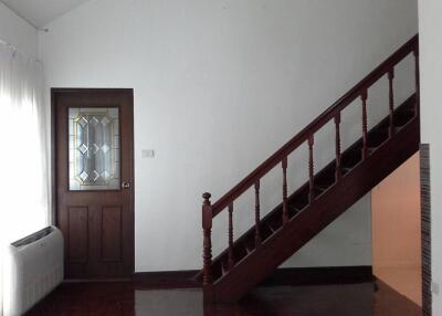 Living room with wooden stairs and door