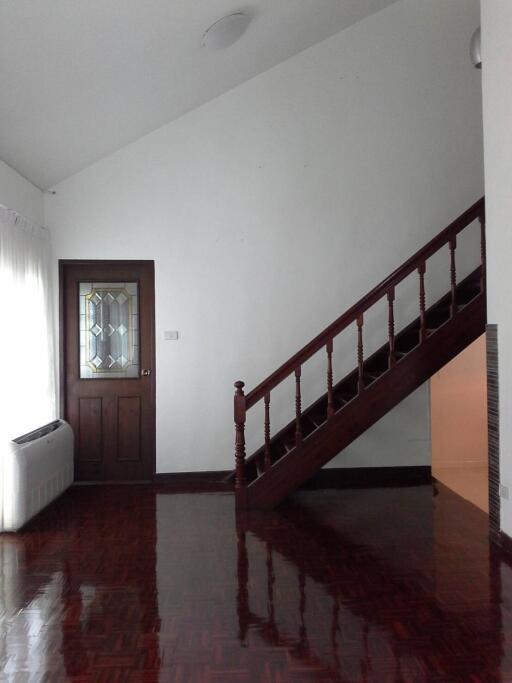 Living room with wooden stairs and door