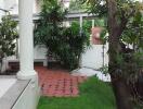 Outdoor garden area with greenery and tiled patio