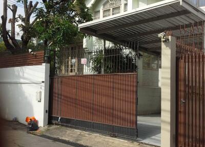 Exterior of a two-story house with a gated driveway