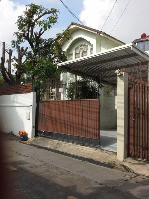 Exterior of a two-story house with a gated driveway