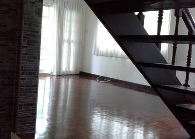 Room with wooden staircase and large window