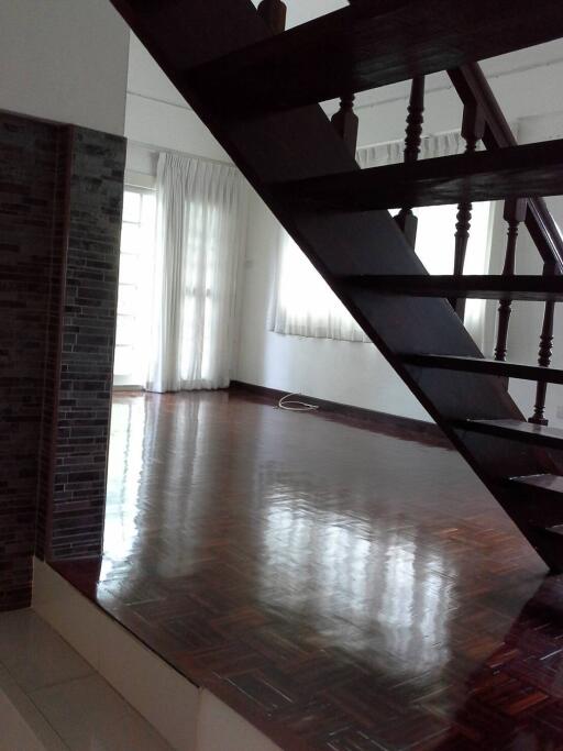 Room with wooden staircase and large window