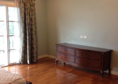 Bedroom with wooden floor and a dresser