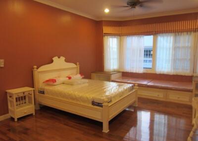 Spacious bedroom with large windows and hardwood floors