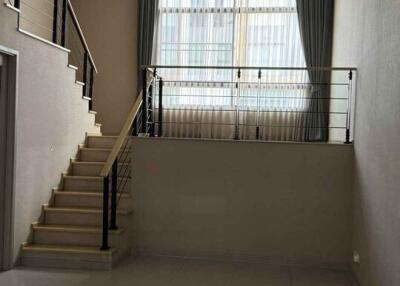 Modern living room with stairs and large windows