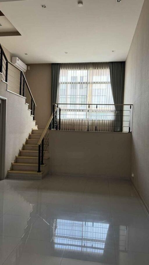 Modern living room with stairs and large windows