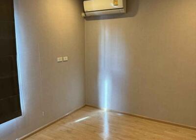 Empty bedroom with wooden floor and air conditioning