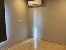 Empty bedroom with wooden floor and air conditioning