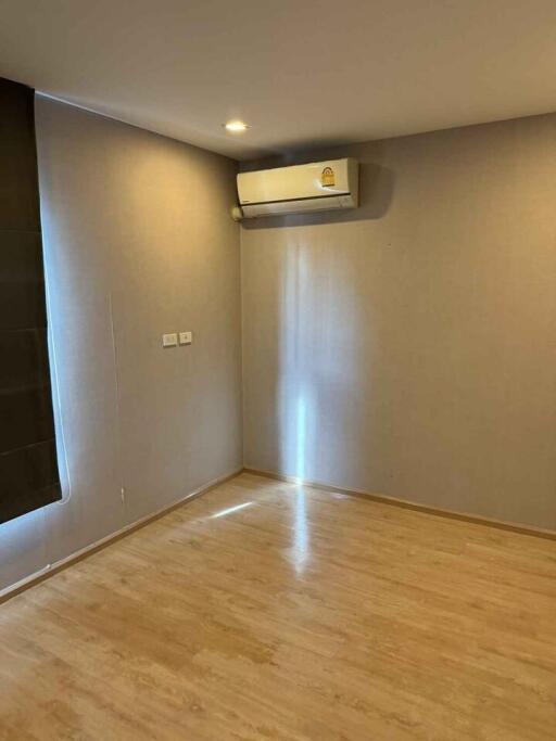 Empty bedroom with wooden floor and air conditioning