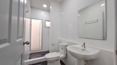 Modern white bathroom with sink, toilet, and shower