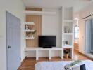 Modern bedroom with a TV, shelves, and balcony access