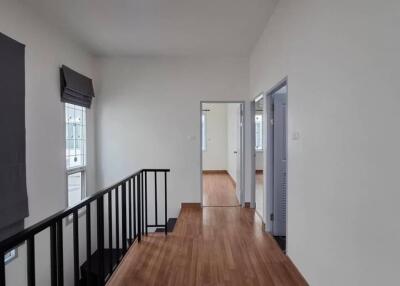 Modern hallway with wooden flooring and natural lighting