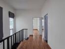 Modern hallway with wooden flooring and natural lighting