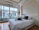 Modern bedroom with large windows and balcony view