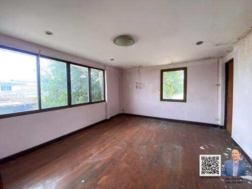 Spacious living room with large windows and wooden flooring