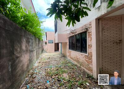 Side view of a building with narrow pathway and greenery