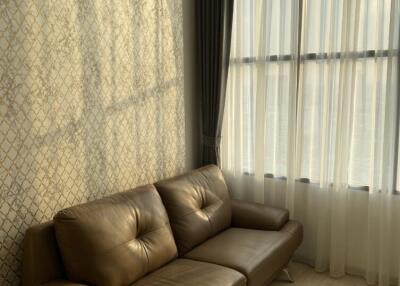 Living room with leather couch and large windows