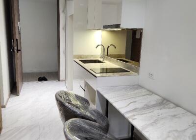 Modern kitchen area with marble countertops and dining space