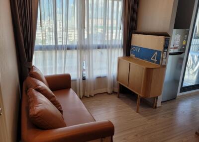 Living room with a sofa, cabinet, and a window with curtains