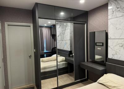 Modern bedroom with sleek furnishings and mirrored closet