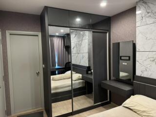 Modern bedroom with sleek furnishings and mirrored closet