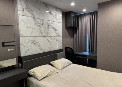 Modern bedroom with marble accent wall and workspace