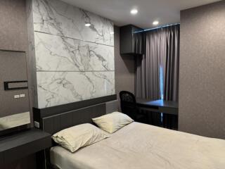 Modern bedroom with marble accent wall and workspace