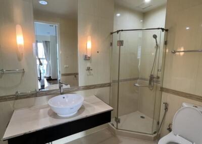 Modern bathroom with glass shower, vanity sink, and toilet