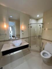 Modern bathroom with glass shower, vanity sink, and toilet