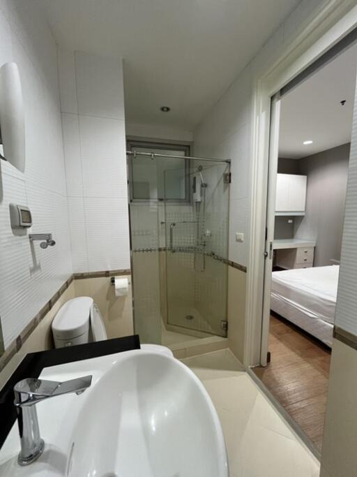 Modern bathroom with a view into bedroom