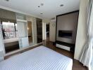 Modern bedroom with striped bed, large closet, and TV mounted on the wall