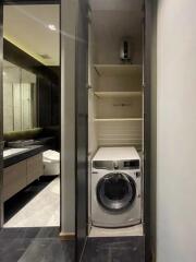 Compact laundry area with washer and shelves