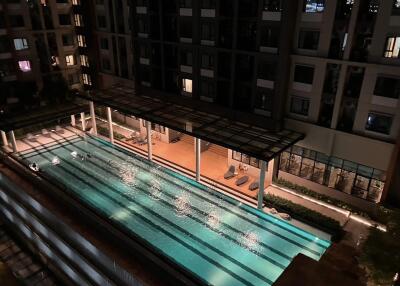 Night view of a modern apartment complex with a swimming pool