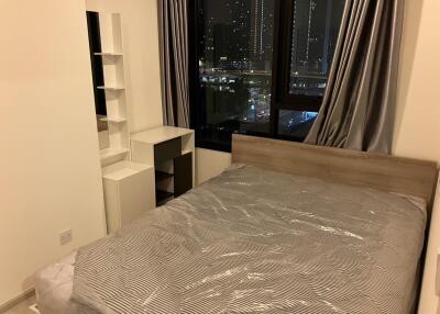 Bedroom with a large window showing city view at night