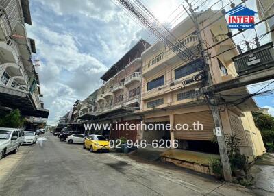 Street view of residential buildings showing multiple levels and parked cars