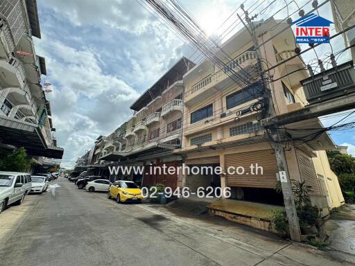 Street view of residential buildings showing multiple levels and parked cars