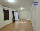 Spacious empty living room with large window, wooden floor, and air conditioning