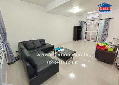 Modern living room with black leather sofa and glass coffee table