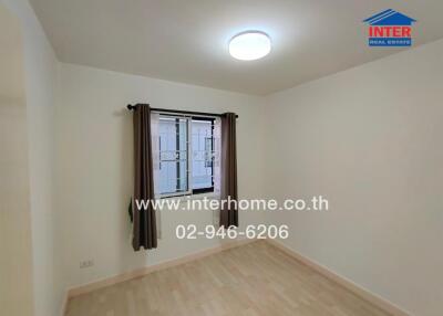 Unfurnished bedroom with a window and wooden flooring