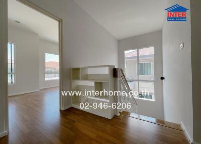 Bright hallway with wooden flooring and large windows