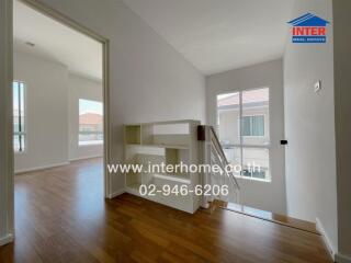 Bright hallway with wooden flooring and large windows