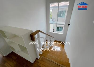 Interior staircase with wooden steps and white railing