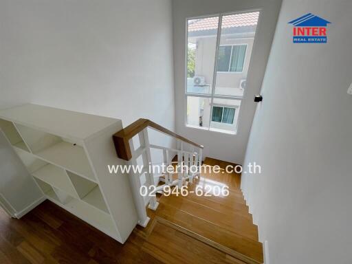 Interior staircase with wooden steps and white railing